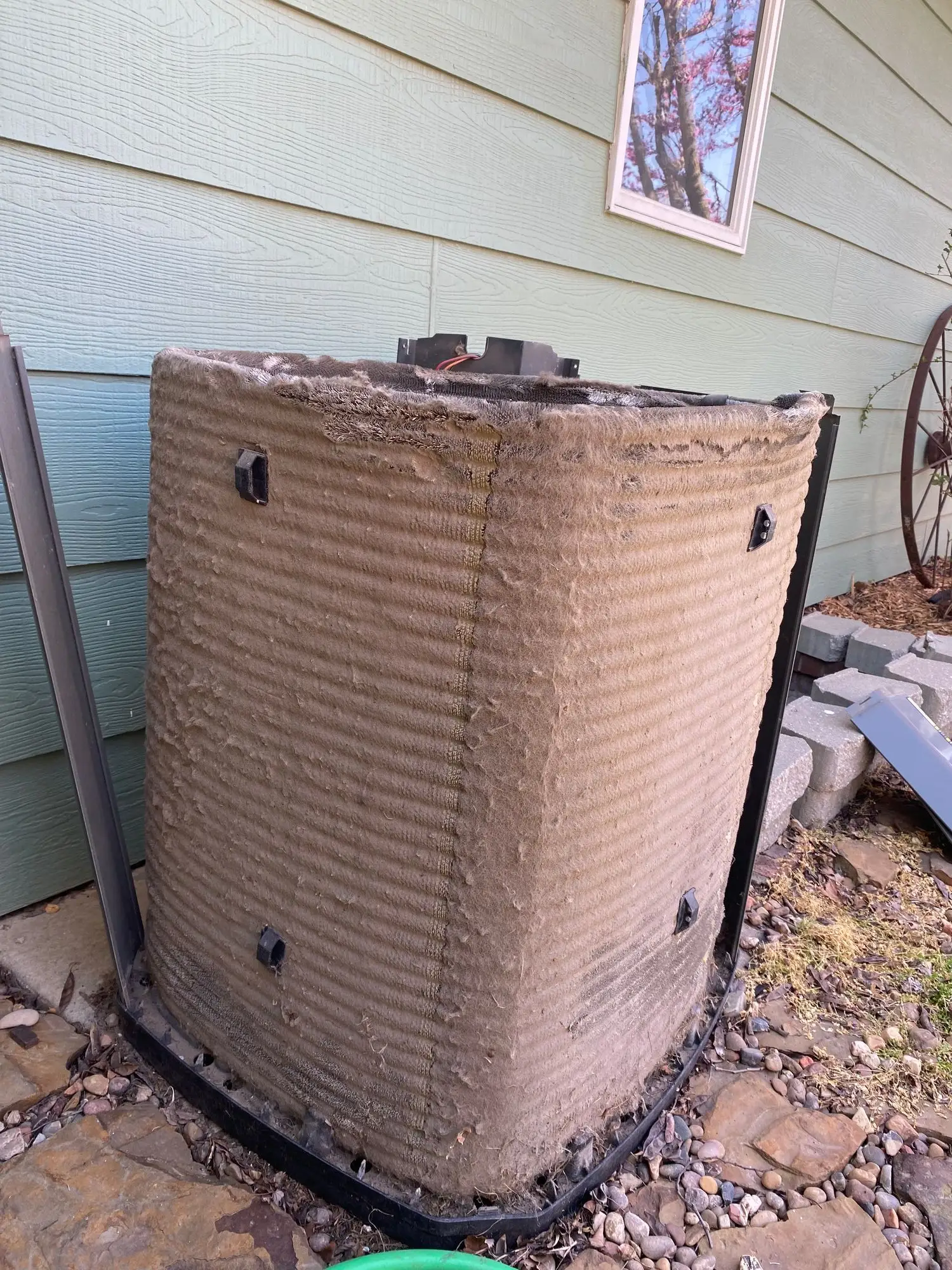 Dirt-clogged AC condenser coil before professional cleaning at a Wichita-area home