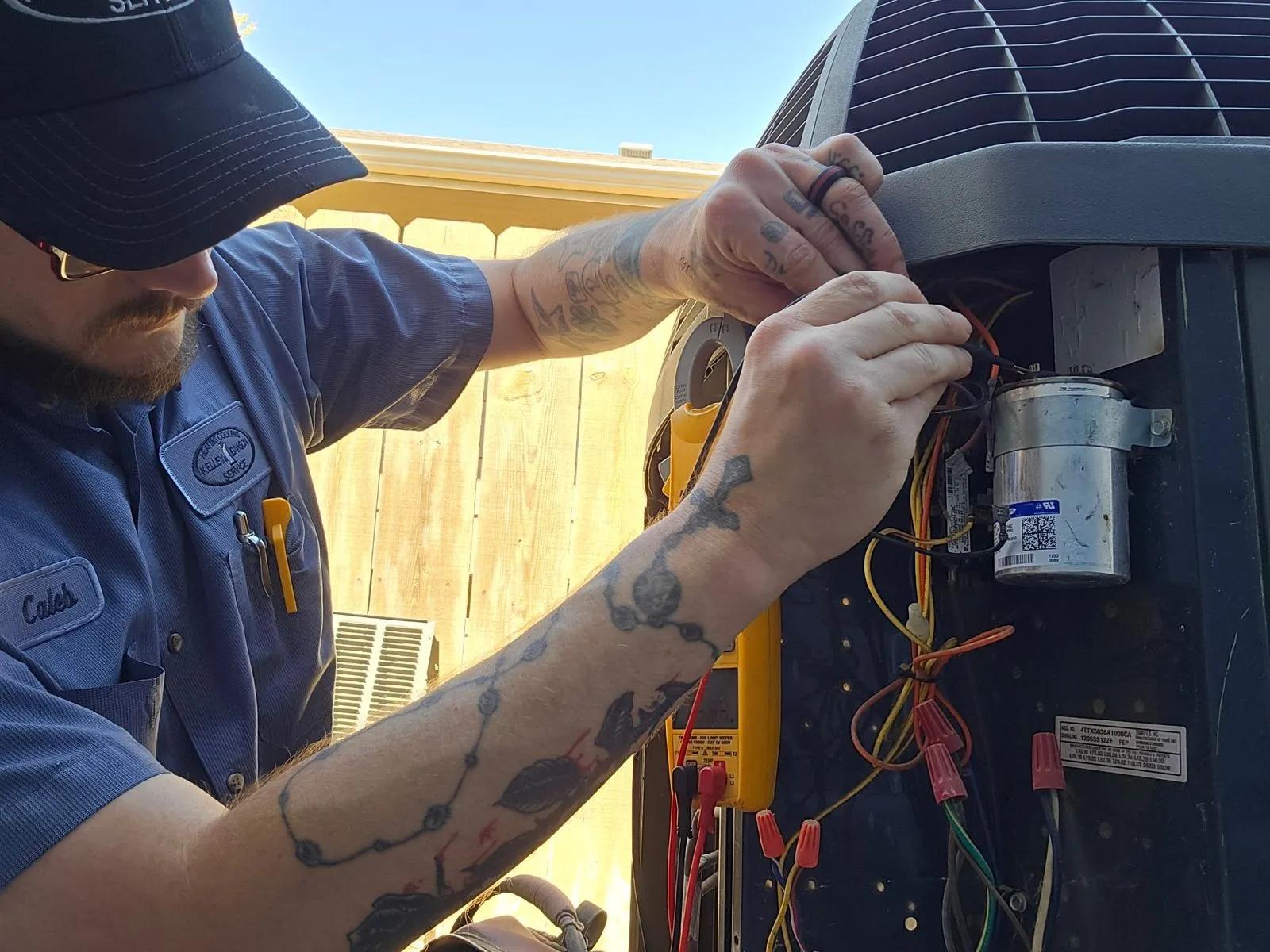 Kelley & Dawson technician repairing an outdoor AC condenser unit