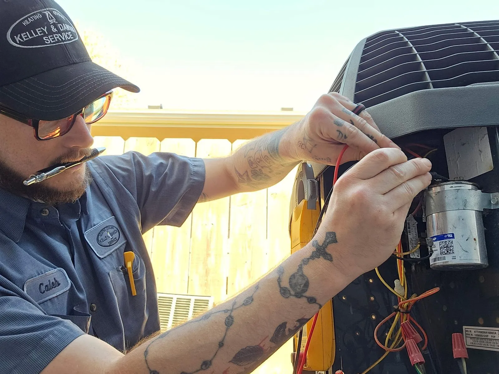 Technician Caleb replacing a run capacitor on a residential AC condenser unit