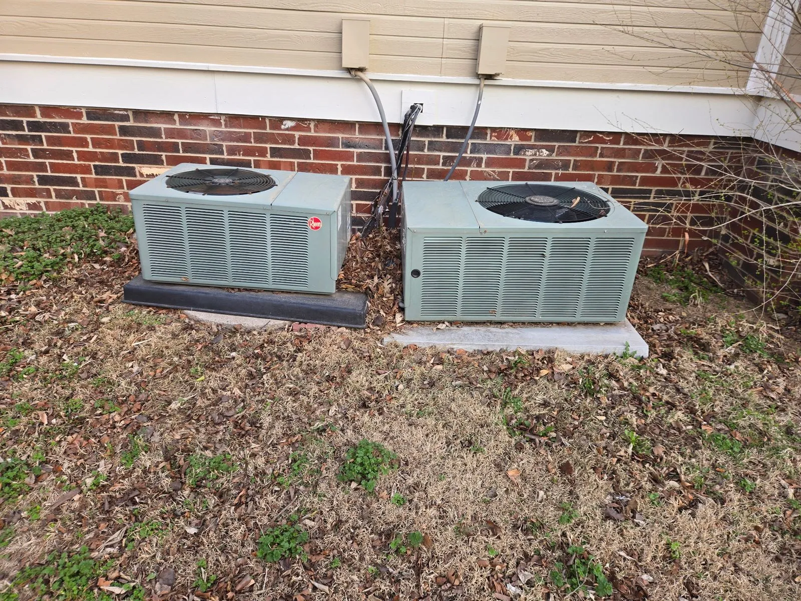 Two Rheem outdoor AC condenser units installed on pads beside a Wichita-area home