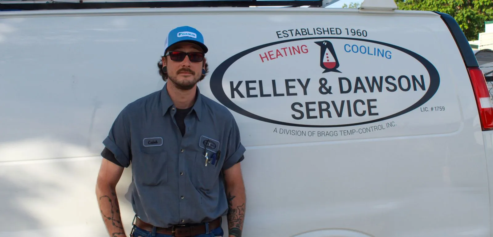 Technician Caleb beside a Kelley & Dawson Service van